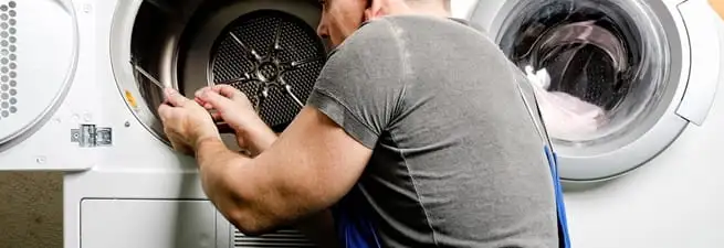 Dryer repair technician fixing a clothes dryer drum in Overland Park, KS