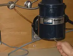 Garbage disposal repair technician tightening the mounting ring under a sink in Overland Park, KS