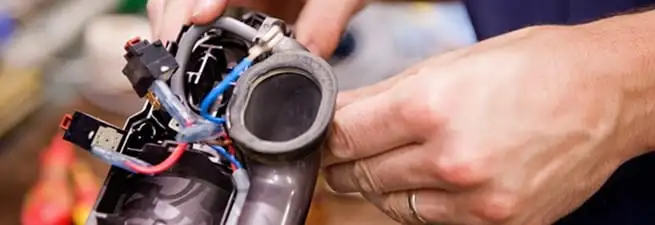 Vacuum repair technician reconnecting wiring and components in Overland Park, KS
