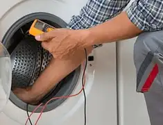Washing machine repair technician testing a front-load washer with diagnostic tools in Overland Park, KS