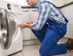 Washing machine repair technician servicing a front-load washer in Overland Park, KS