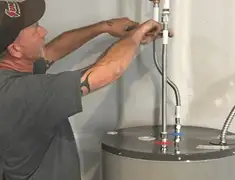 Water heater repair technician tightening supply line connections in Overland Park, KS
